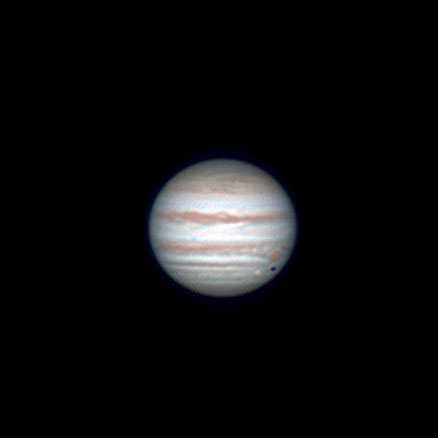 Image of the planet Jupiter, showing cloud belts, the great red spot, and three of the Galilean moons: Europa, which is transiting Jupiter's disc, Io, and Ganymede